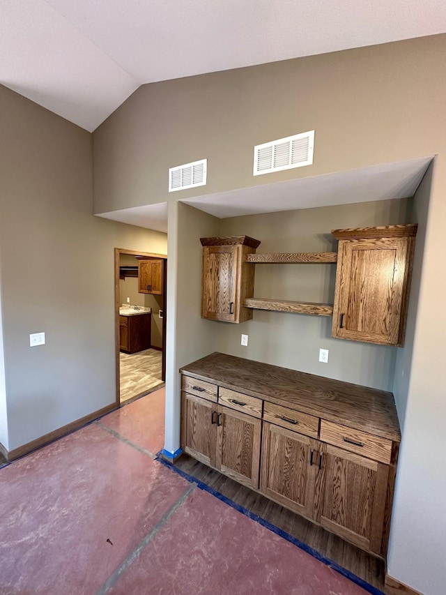 212 Woolgrass Way, Avon, MN 56310 - kitchen with open shelves, dark countertops, baseboards, brown cabinets, and high vaulted ceiling