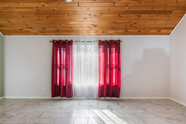 empty room with wooden ceiling, baseboards, lofted ceiling, and marble finish floor