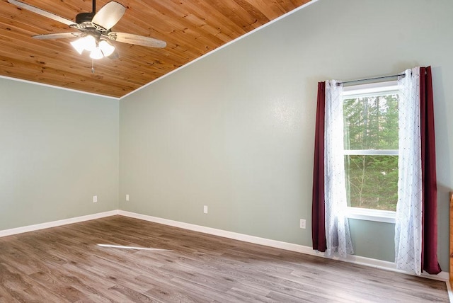 empty room with a ceiling fan, vaulted ceiling, wood ceiling, and wood finished floors