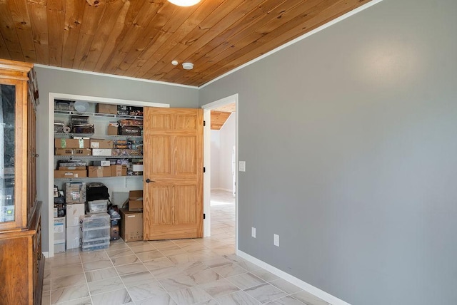 unfurnished room featuring crown molding, baseboards, wood ceiling, and marble finish floor