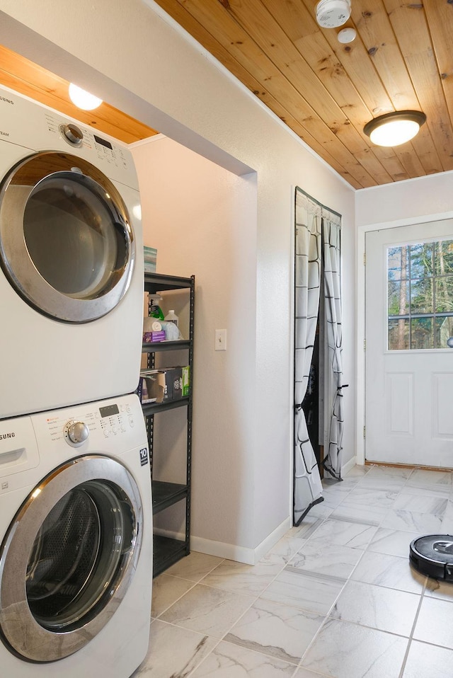 laundry area featuring wood ceiling, laundry area, baseboards, marble finish floor, and stacked washer and clothes dryer