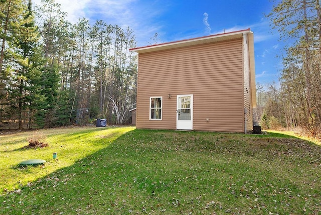back of house featuring a lawn and central AC