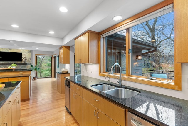 kitchen with open floor plan, dark stone countertops, recessed lighting, a sink, and light wood finished floors