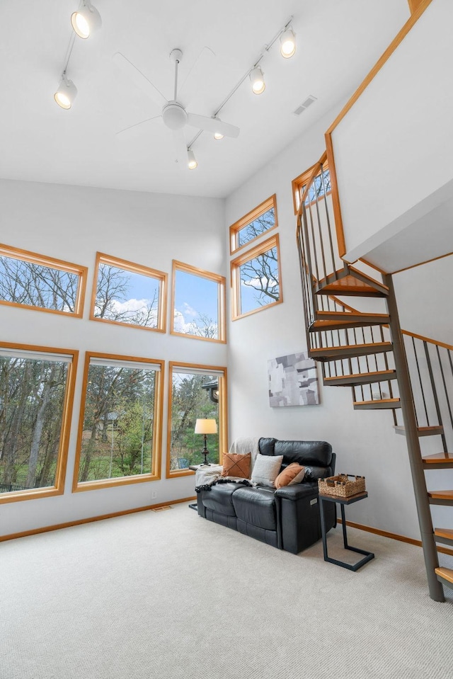 living area with visible vents, stairs, carpet flooring, ceiling fan, and rail lighting