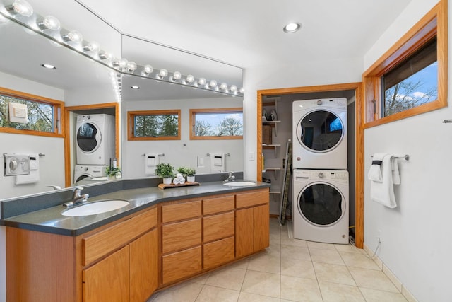 laundry area featuring a sink, stacked washer / drying machine, and laundry area