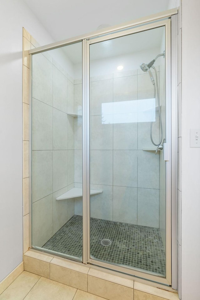 bathroom featuring tile patterned flooring and a shower stall