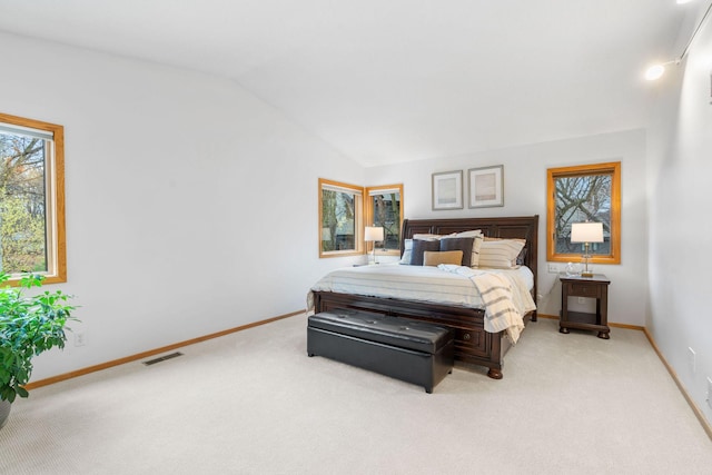 bedroom with visible vents, baseboards, lofted ceiling, and light colored carpet