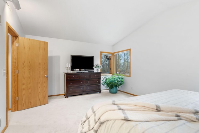bedroom featuring baseboards, vaulted ceiling, and light carpet