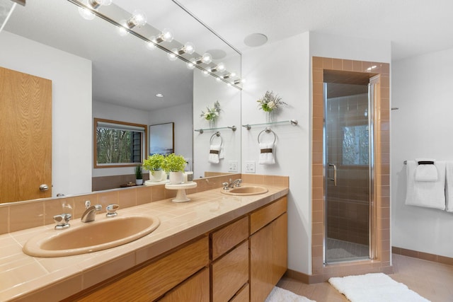 full bathroom with baseboards, tile patterned floors, a sink, and a stall shower