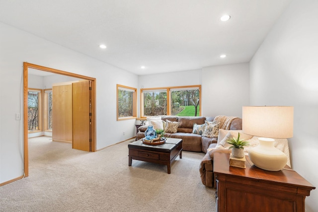living area featuring recessed lighting, baseboards, and light carpet