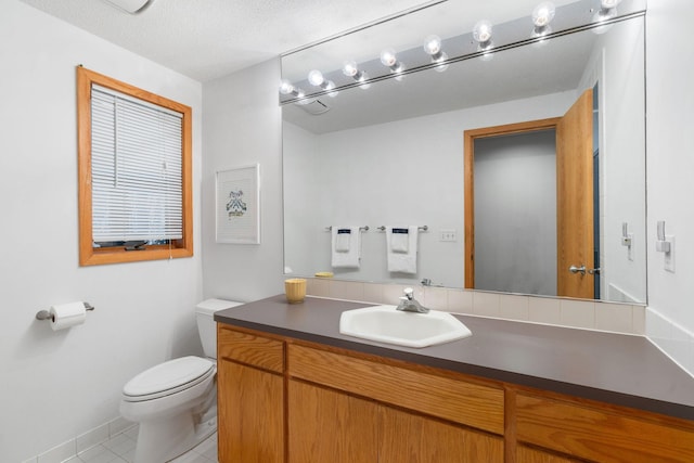 bathroom with toilet, baseboards, tile patterned flooring, and vanity