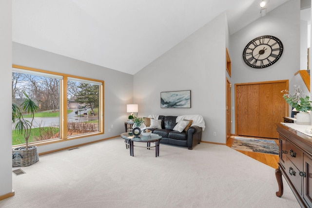 living area featuring baseboards, carpet, visible vents, and high vaulted ceiling