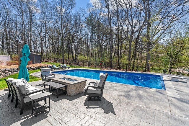 view of pool with a fenced in pool, a fenced backyard, a patio area, and an outdoor fire pit