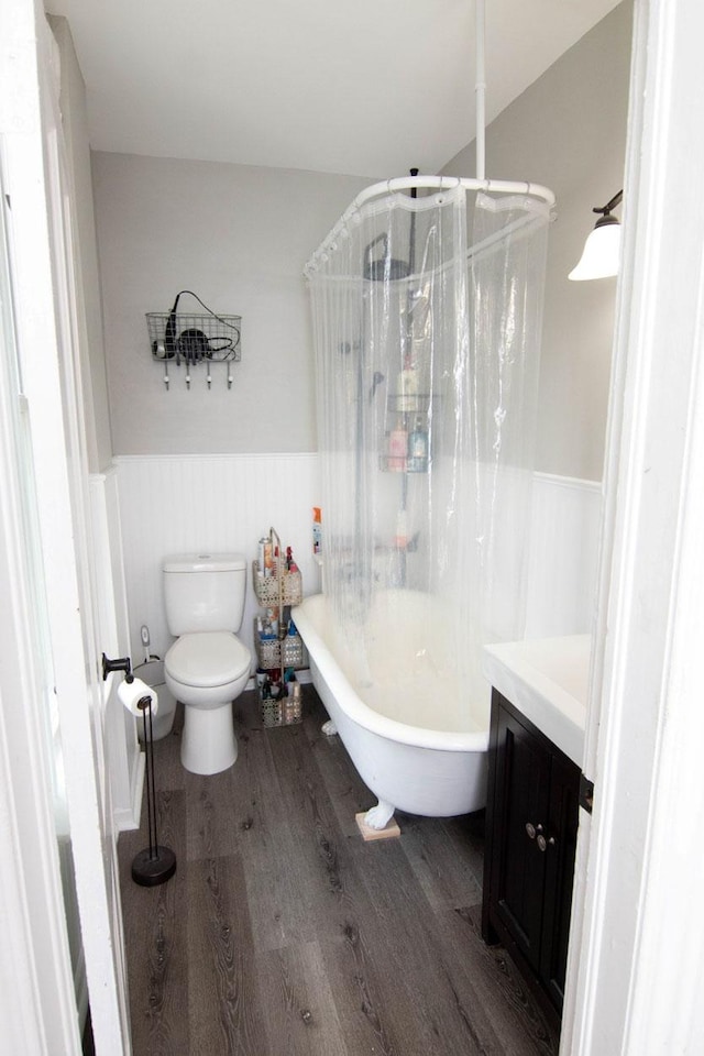 217 Center St, Mankato, MN 56001 - full bath featuring wainscoting, a soaking tub, toilet, and wood finished floors