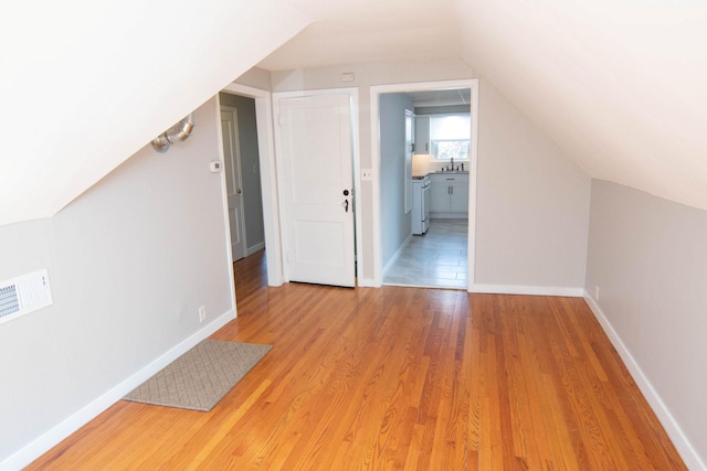 217 Center St, Mankato, MN 56001 - additional living space with a sink, baseboards, light wood-type flooring, and vaulted ceiling