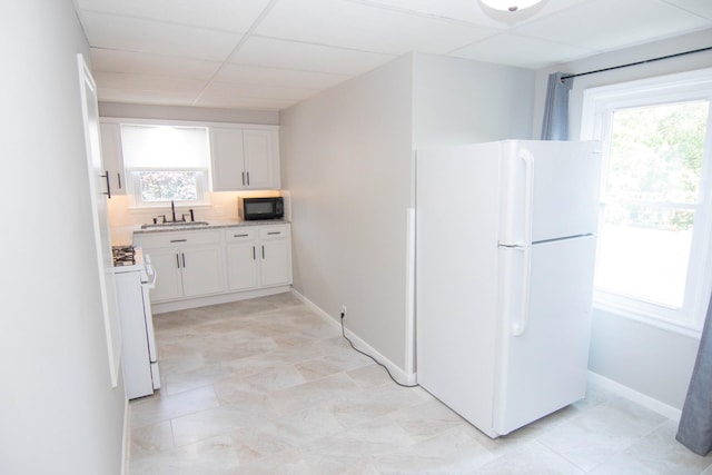 217 Center St, Mankato, MN 56001 - kitchen with white cabinets, white appliances, a sink, and a healthy amount of sunlight
