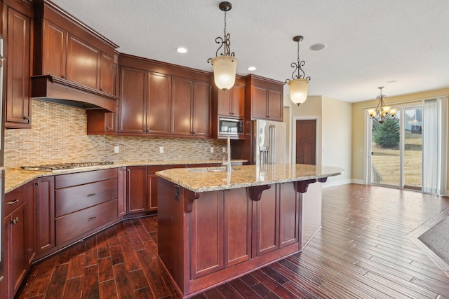 kitchen featuring premium range hood, a chandelier, dark wood-style floors, stainless steel appliances, and decorative backsplash