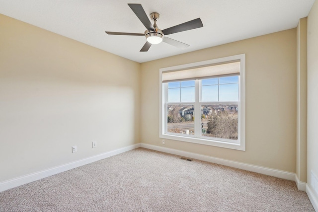 unfurnished room with visible vents, baseboards, ceiling fan, and light colored carpet