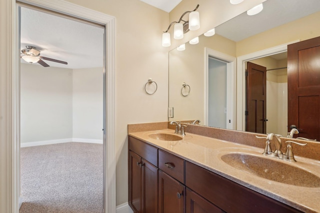 bathroom featuring double vanity, baseboards, a sink, and a ceiling fan