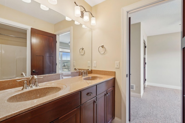 full bath with a sink, visible vents, baseboards, and double vanity