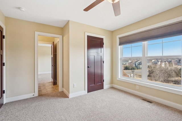 unfurnished bedroom featuring visible vents, baseboards, a ceiling fan, and carpet floors