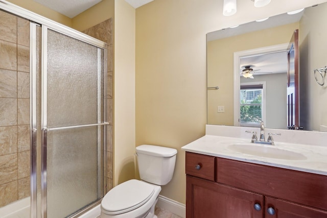 full bathroom featuring ceiling fan, a shower stall, vanity, toilet, and baseboards