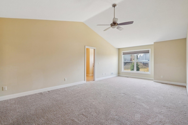 carpeted empty room with ceiling fan, baseboards, and lofted ceiling