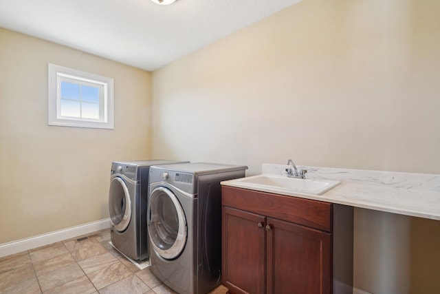 clothes washing area featuring visible vents, baseboards, a sink, cabinet space, and washing machine and dryer