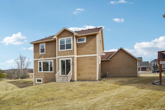 back of property featuring central air condition unit, entry steps, a shingled roof, and a lawn