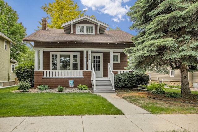 509 Nicollet Ave, North Mankato, MN 56003 - view of front of house with a chimney, a porch, a front yard, and a shingled roof