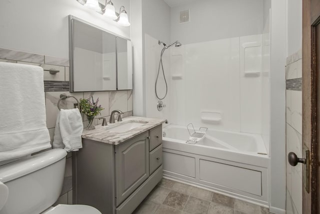 509 Nicollet Ave, North Mankato, MN 56003 - full bathroom featuring vanity, toilet, washtub / shower combination, and tile walls