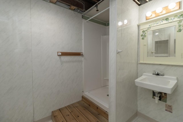 509 Nicollet Ave, North Mankato, MN 56003 - full bathroom featuring walk in shower, a sink, wood finished floors, and tile walls