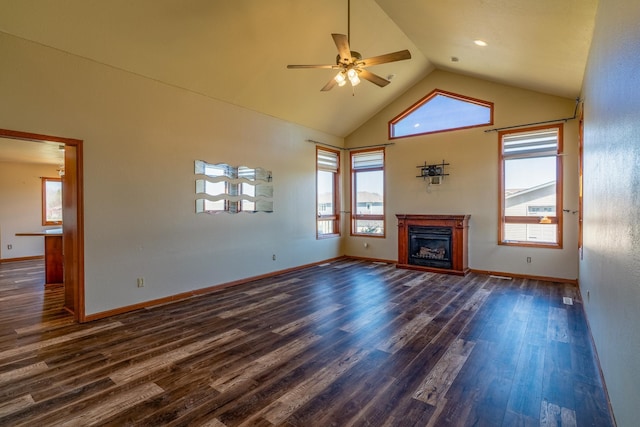 unfurnished living room with dark wood-type flooring, ceiling fan, a glass covered fireplace, and baseboards