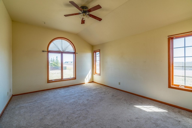 carpeted empty room featuring baseboards, a ceiling fan, and lofted ceiling