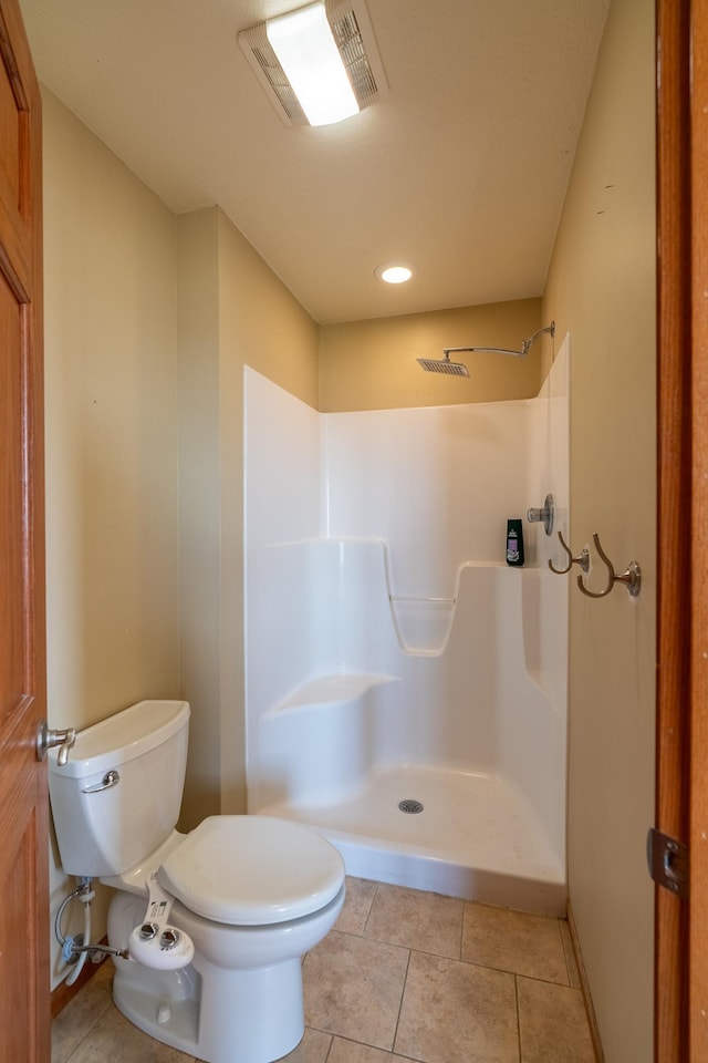 bathroom featuring visible vents, toilet, a shower, and tile patterned floors