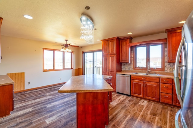 kitchen with dark wood-type flooring, appliances with stainless steel finishes, a sink, and light countertops