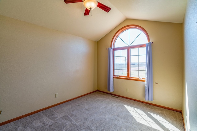 carpeted spare room with lofted ceiling, baseboards, and ceiling fan