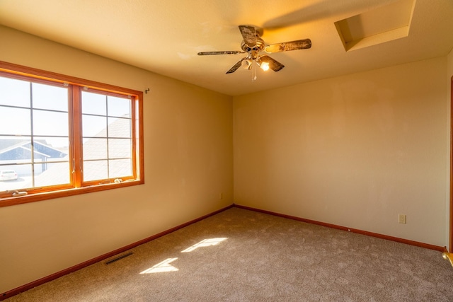 spare room featuring ceiling fan, visible vents, baseboards, and carpet floors