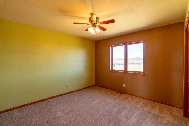unfurnished room featuring carpet floors, baseboards, and a ceiling fan