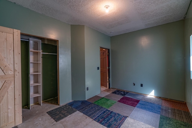 unfurnished bedroom featuring a textured ceiling and a closet