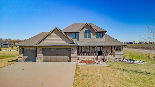view of front of property featuring concrete driveway, roof with shingles, an attached garage, a front yard, and a porch