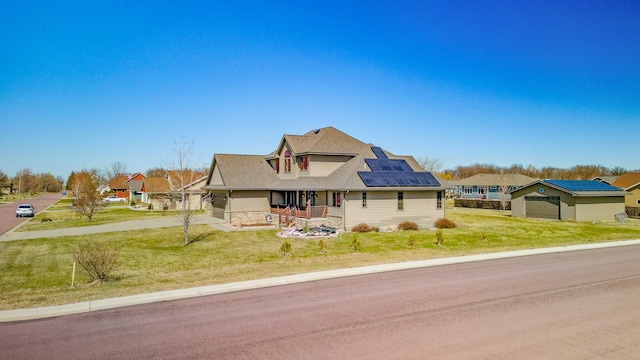 view of front facade featuring an outbuilding, covered porch, stone siding, a front lawn, and concrete driveway