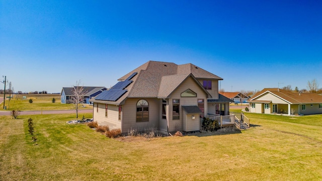 view of front of house featuring a front yard and a shingled roof