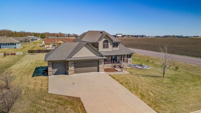 view of front of property with a front yard, stone siding, an attached garage, and covered porch