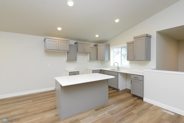 kitchen featuring gray cabinetry, a sink, a kitchen island, and recessed lighting