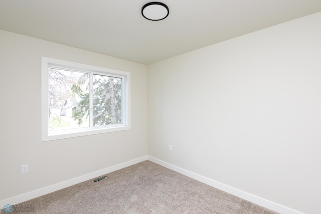 carpeted empty room featuring visible vents and baseboards