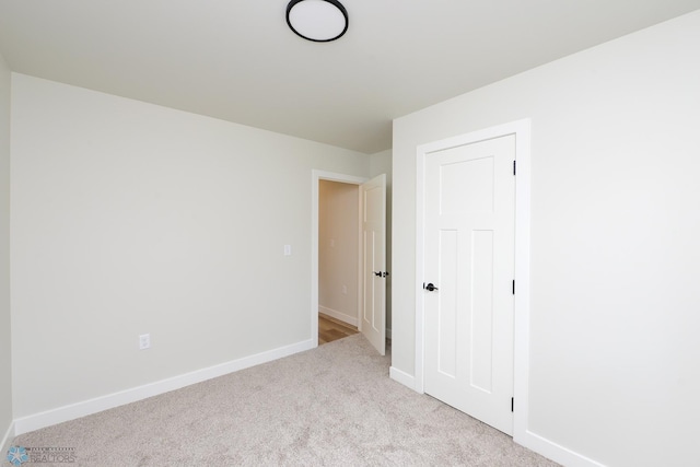 carpeted empty room featuring baseboards