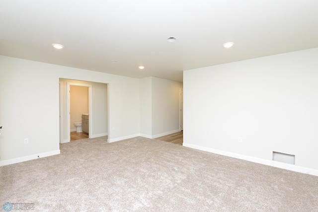 spare room with recessed lighting, baseboards, and light carpet