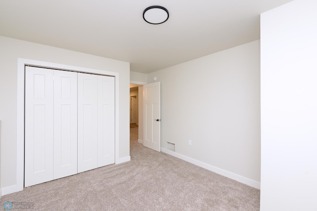 unfurnished bedroom featuring a closet, carpet, visible vents, and baseboards