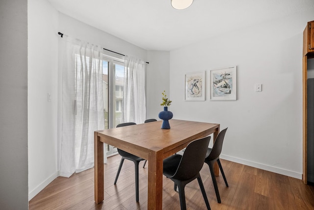 dining area with baseboards and wood finished floors